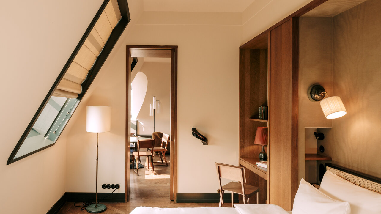 Das Schlafzimmer der größten Suite des Château Royal Berlin mit Blick auf den Wohnbereich mit Kunst von Alicja Kwade.