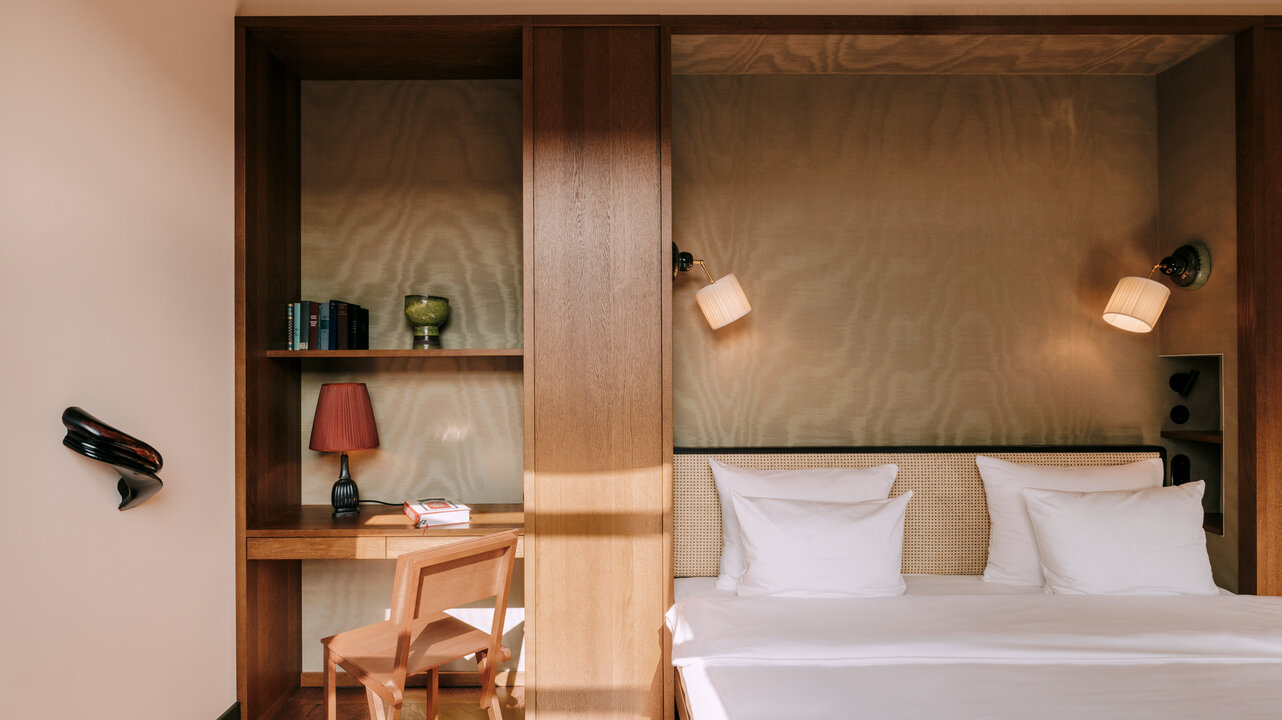 Bed and desk in the bedroom of the largest suite at the Château Royal Berlin with art by Alicja Kwade.