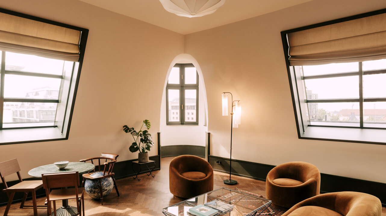 View of the living room of the largest suite at Château Royal Berlin with several seats and art by Alicja Kwade