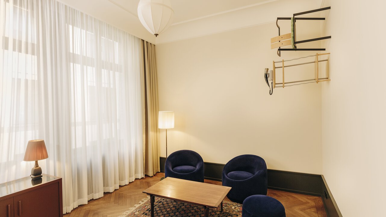 View of the living area of ​​a junior suite in the Château Royal Berlin with art by Henrike Naumann on the right wall.