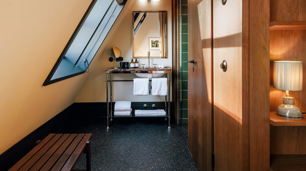 Stylish small bathroom in one of the smaller hotel rooms in the Châtesu Royal Berlin, which is located under a sloping roof.