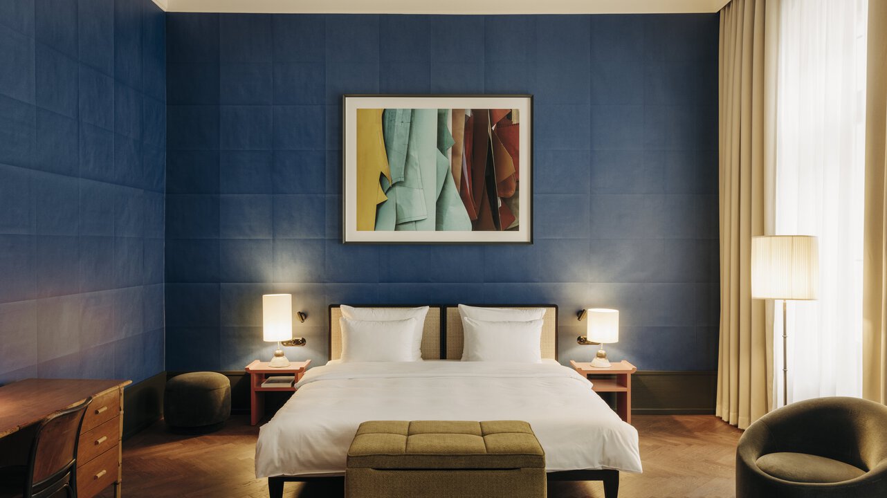 View of the sleeping area of ​​a suite in the boutique hotel Château Royal, with an artwork by Thomas Demand above the bed.