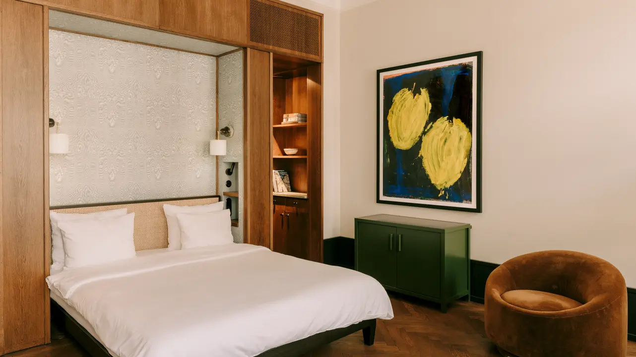 View of the sleeping area of ​​a suite at the Château Royal Berlin with an artwork by Helmut Middendorf on the wall.