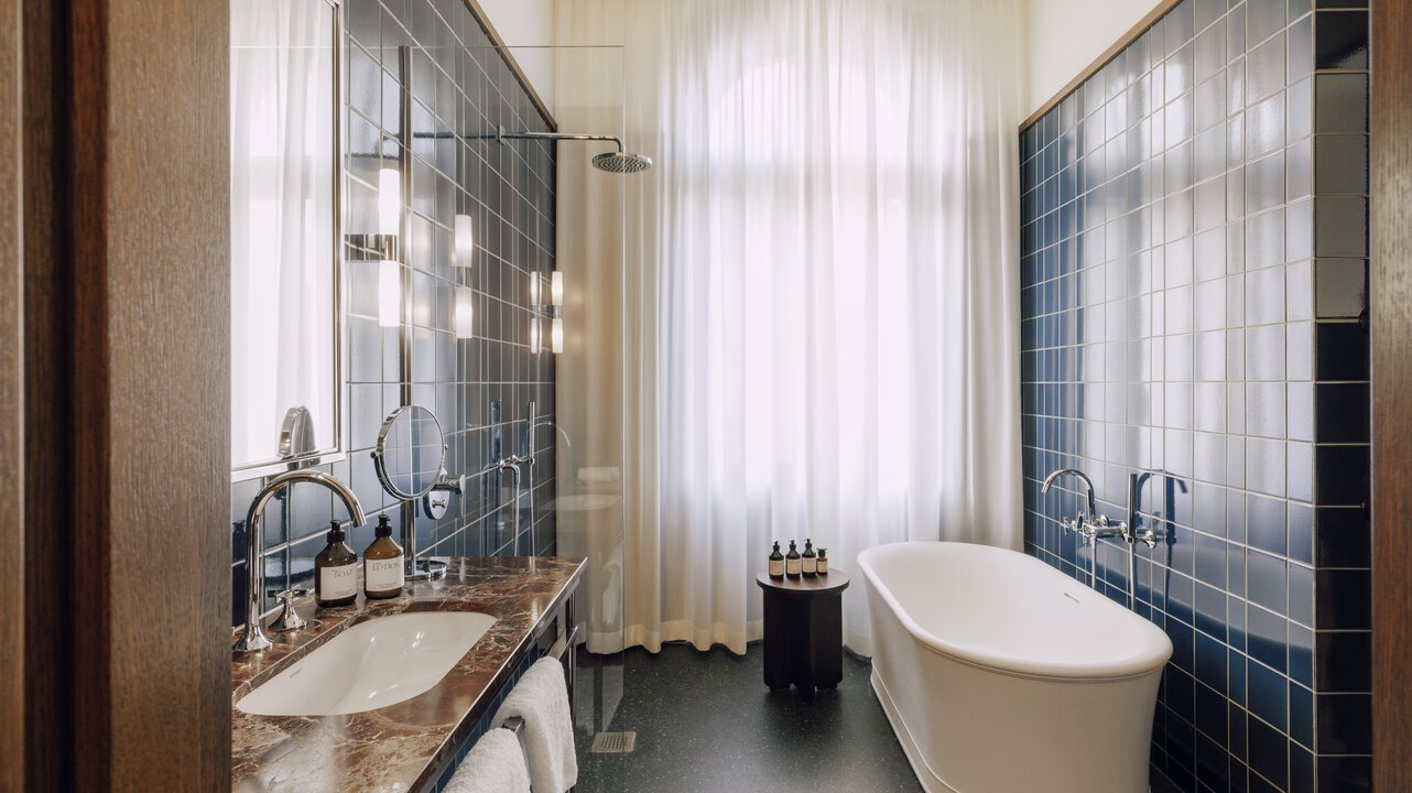 The bathroom of the Tower Suite at the boutique hotel Château Royal, which is equipped with a bathtub and a shower.