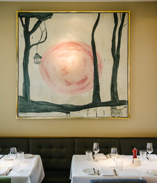 Kontrastreiches Kunstwerk über den elegant mit weißen Tischdecken eingedeckten Tischen im Restaurant Le Petit Royal, der kleinen Schwester des Restaurants Grill Royal