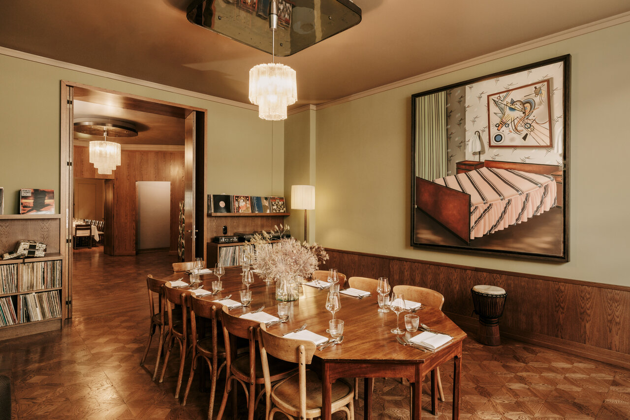 View of a simply laid table for eight people in the music room of the Château Royal, which is equipped with a large record collection and is available as an event location in Berlin Mitte